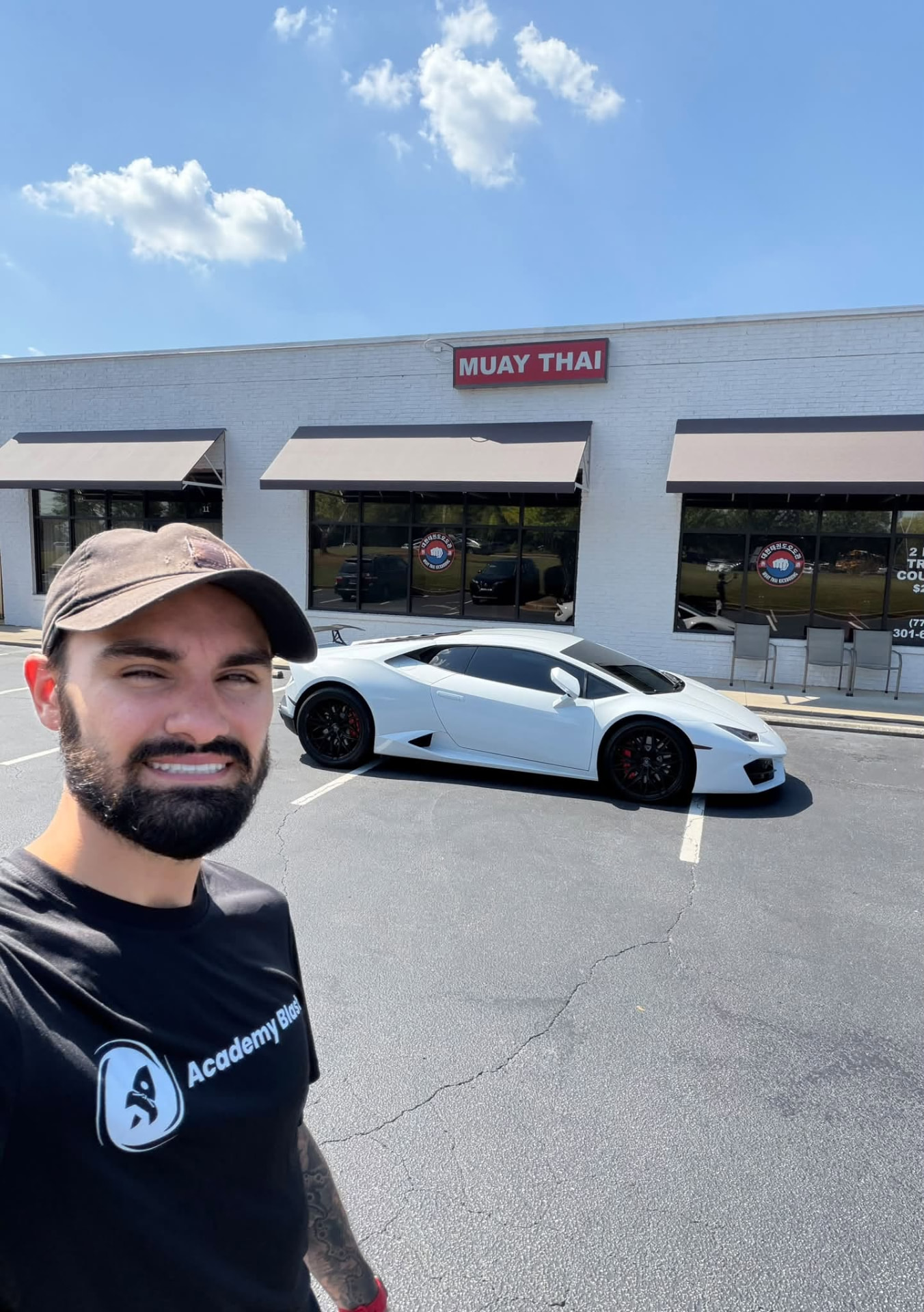 Bryce Bonilla outside ODK Striking Academy Muay Thai with a white Lamborghini