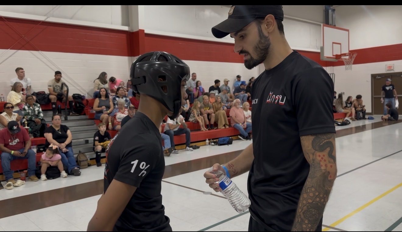 Bryce Bonilla coaching a young fighter at an event